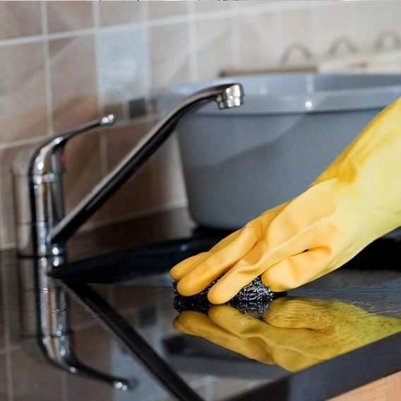 house cleaner cleaning kitchen counter and sink