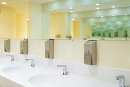 Modern public toilet room with wash basin and mirrors