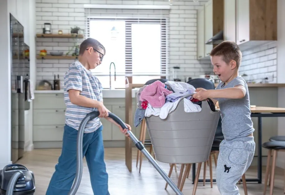 Two little boys help with the laundry and cleaning of the house