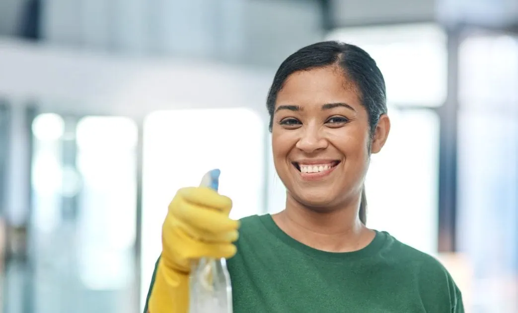 Portrait of a young woman cleaning a modern office