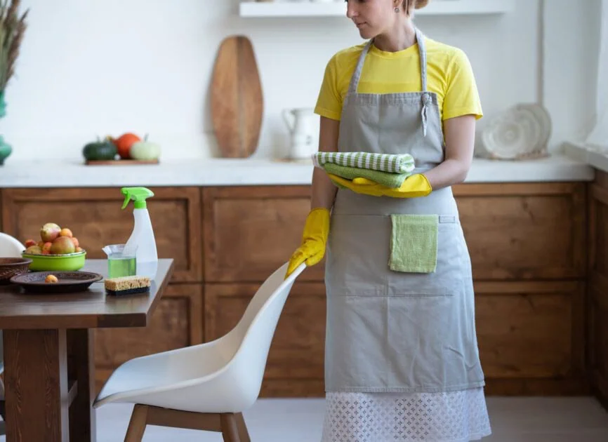 cleaning service a woman in a gray apron and yell utc