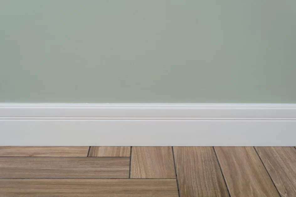 light green matte wall, with clean white baseboard